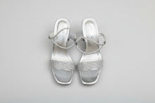 Load image into Gallery viewer, Pair of silver glittery sandals on a concrete floor