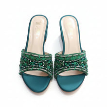 Load image into Gallery viewer, Pair of teal high-heeled shoes with green beading on a gray surface