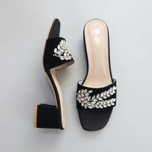 Load image into Gallery viewer, Black high-heeled shoes with silver embellishments on a gray surface