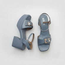 Load image into Gallery viewer, Pair of blue sandals with buckles on a textured surface
