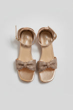 Load image into Gallery viewer, Pair of rose gold sandals with bow details on a gray surface