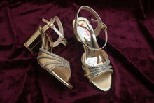 Load image into Gallery viewer, Gold high-heeled shoes with decorative straps on a gray surface