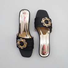 Load image into Gallery viewer, Black high-heeled shoes with decorative gold buckles on a gray surface