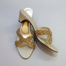 Load image into Gallery viewer, Gold glittery high-heeled shoes on a gray marble surface