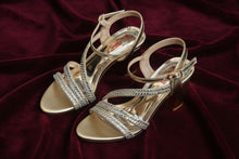 Load image into Gallery viewer, Gold high-heeled sandals with a platform sole on a gray surface