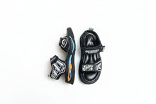 Load image into Gallery viewer, Black children's sandals with colorful accents on a gray surface