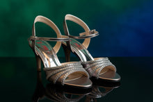 Load image into Gallery viewer, Pair of metallic sandals with braided straps on a gray surface