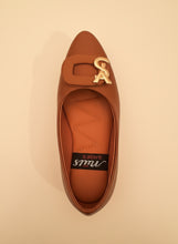 Load image into Gallery viewer, Brown flat shoe with gold logo on a dark background