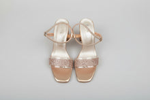 Load image into Gallery viewer, Pair of gold high-heeled sandals with rhinestone embellishments on a gray surface.