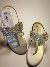 Load image into Gallery viewer, Gold sandals with butterfly embellishments on a wooden surface