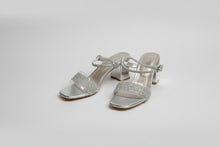 Load image into Gallery viewer, Pair of silver high-heeled shoes with glittery details on a brown surface
