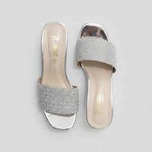Load image into Gallery viewer, Silver glittery high-heeled shoes on a gray marble surface