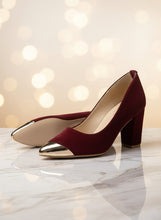 Load image into Gallery viewer, Pair of maroon high heels with gold toes on a concrete surface

