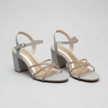 Load image into Gallery viewer, Pair of strappy high-heeled shoes on a textured gray surface
