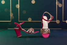 Load image into Gallery viewer, Red high-heeled shoes with gold embellishments on a gray surface
