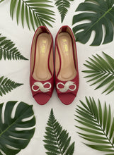 Load image into Gallery viewer, Red high-heeled shoes with gold embellishments on a dark blue background
