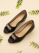 Load image into Gallery viewer, Black high-heeled shoes with gold embellishments on a dark blue background
