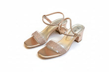 Load image into Gallery viewer, Pair of rose gold sandals with embellishments on a gray concrete surface

