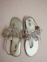 Load image into Gallery viewer, Pair of sandals with butterfly embellishments on a gray surface
