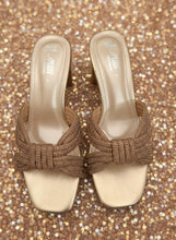 Load image into Gallery viewer, Pair of beige high-heeled sandals with decorative bow on a dark background
