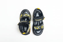 Load image into Gallery viewer, Black and yellow sandals with 'Speed' branding on a gray surface
