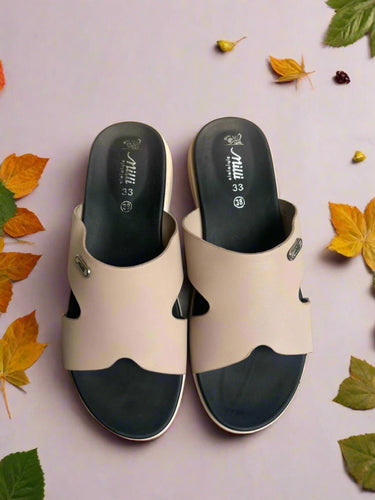 Pair of beige and black sandals on a textured surface