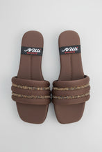 Load image into Gallery viewer, Pair of brown sandals with decorative straps on a gray surface
