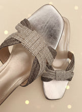 Load image into Gallery viewer, Gold sandal with rhinestone straps on a dark background
