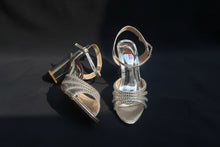Load image into Gallery viewer, Silver strappy high-heeled shoes on a reflective surface
