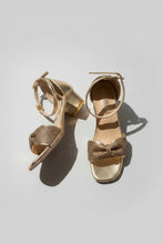 Load image into Gallery viewer, Gold high-heeled sandals with rhinestone embellishments on a gray surface
