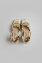Load image into Gallery viewer, Gold sandals with rhinestone straps on a gray surface
