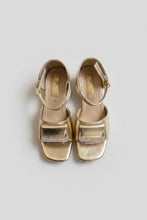 Load image into Gallery viewer, Gold sandals with rhinestone details on a gray surface
