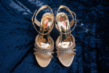 Load image into Gallery viewer, Pair of gold sandals with metallic finish on a gray surface
