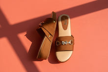 Load image into Gallery viewer, Brown leather sandal with decorative strap on a concrete surface
