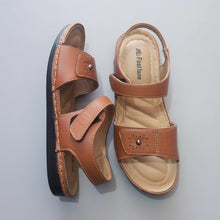 Load image into Gallery viewer, Pair of brown sandals on a gray stone surface
