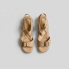 Load image into Gallery viewer, Pair of beige sandals with gold buckles on a gray surface
