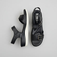 Load image into Gallery viewer, Pair of black sandals with buckles on a beige surface

