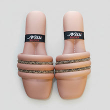 Load image into Gallery viewer, Pair of sandals with decorative straps on a textured surface
