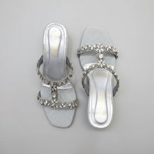 Load image into Gallery viewer, Silver glittery sandals with rhinestone embellishments on a gray surface
