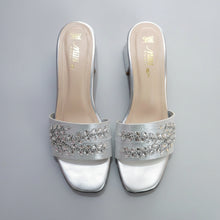 Load image into Gallery viewer, Silver high-heeled shoes with embellishments on a gray surface

