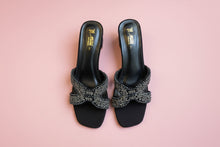 Load image into Gallery viewer, Black high-heeled shoes with embellishments on a gray surface
